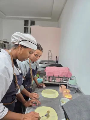 two women in a kitchen preparing food on a table at atelier de cuisine in Marrakech