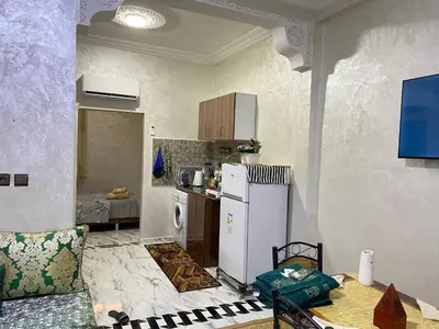 a kitchen with a refrigerator and a table in a room at Cosy, Calm Apartment - Wi-Fi, AC & NETFLIX in Marrakech