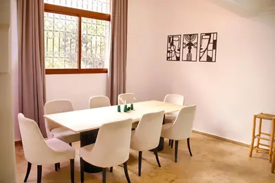 a dining room with a table and white chairs at Gueliz Appartement in Marrakech