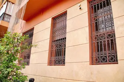 two windows with bars on the side of a building at Gueliz Appartement in Marrakech