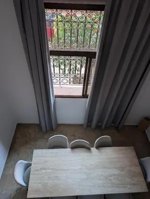 a table and chairs in a room with a window at Gueliz Appartement in Marrakech