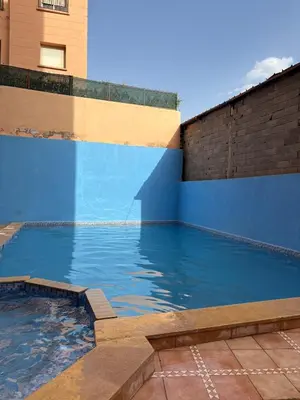 a swimming pool with a blue wall and water at Apartment with pool in Marrakech
