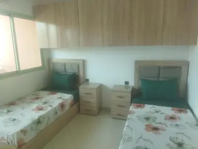 a bedroom with two beds and two night stands at Appartement Marrakech in Marrakech