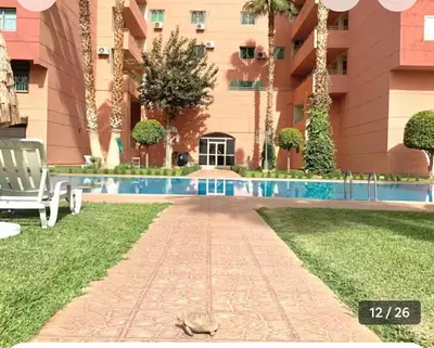a resort with a swimming pool in front of a building at Appartement Marrakech in Marrakech
