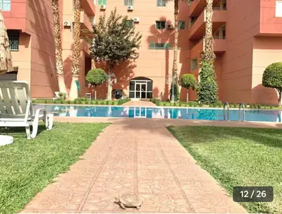 a resort with a swimming pool in front of a building at Appartement Marrakech in Marrakech
