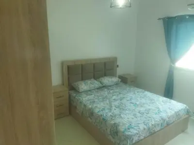a bedroom with a bed and a dresser with a blue bedspread at Appartement Marrakech in Marrakech