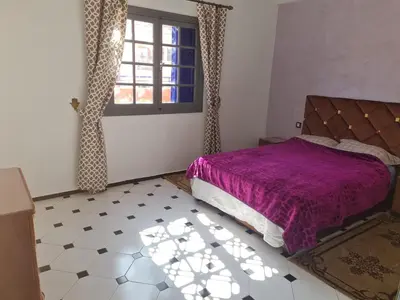 a bedroom with a purple bed and a window at Apart plein centre in Marrakech