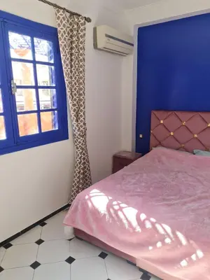 a bedroom with a pink bed and a window at Apart plein centre in Marrakech
