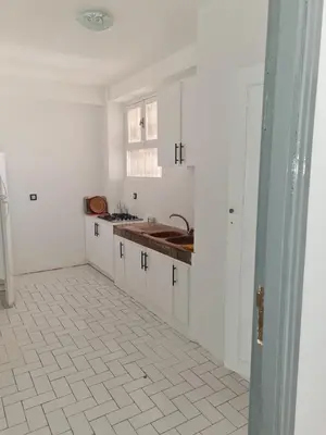 a kitchen with white cabinets and a sink at Apart plein centre in Marrakech
