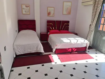 two beds in a room with red and white at Apart plein centre in Marrakech
