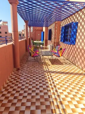 a patio with chairs and tables on a roof at Apart plein centre in Marrakech