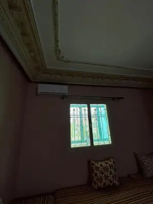 a room with a window and a bed with pillows at Appartement a louer a massira 3 marrakech in Marrakech