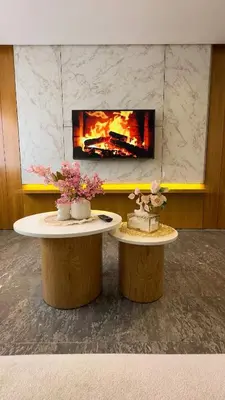 two tables with flowers on top of them in front of a fireplace at Éden Luxueux au Cœur de la Ville in Marrakech