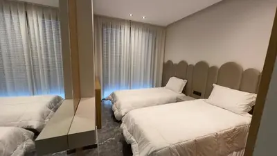 a hotel room with two beds and a window at Éden Luxueux au Cœur de la Ville in Marrakech