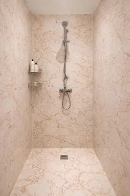 a shower in a bathroom with a stone wall at Marrakech prestige in Marrakech