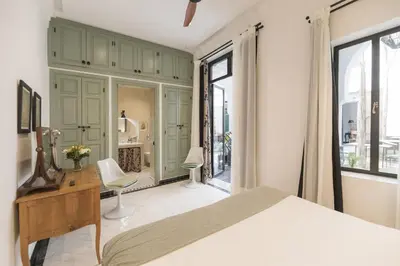 a bedroom with a bed and a desk and window at Riad Palazzo Montefiore in Marrakech