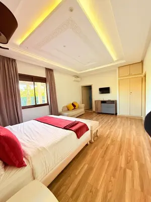 a large bedroom with a large bed and a kitchen at Villa ghina in Marrakech