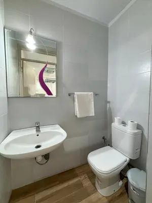 a white bathroom with a sink and a toilet at Villa ghina in Marrakech