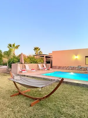 a boat sitting on the grass next to a swimming pool at Villa ghina in Marrakech