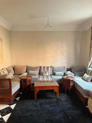 a living room with a couch and a table at Al Qaria Syahia Duplex Moufid in Marrakech