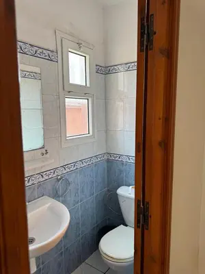a bathroom with a toilet and a sink and a window at Al Qaria Syahia Duplex Moufid in Marrakech