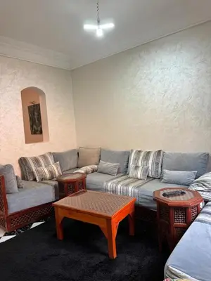 a living room with a couch and a coffee table at Al Qaria Syahia Duplex Moufid in Marrakech