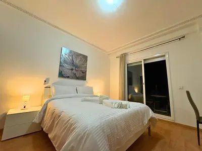 a white bedroom with a bed and a window at Trésor de Gueliz avec Piscine et Terrasse in Marrakech