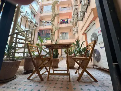 two chairs and a table on a balcony with plants at Trésor de Gueliz avec Piscine et Terrasse in Marrakech