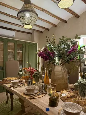 a wooden table with plates and flowers on it at Riad Secret by Dar n alla in Marrakech