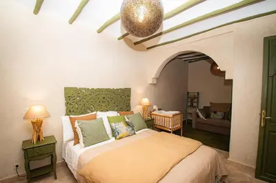 a bedroom with a bed and a living room at Riad Secret by Dar n alla in Marrakech