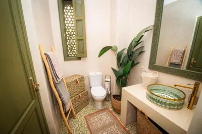 a bathroom with a toilet and a sink and a mirror at Riad Secret by Dar n alla in Marrakech