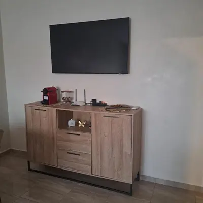 a flat screen tv on top of a wooden cabinet at Luxury 2 Bedrooms Apartment in Marrakech