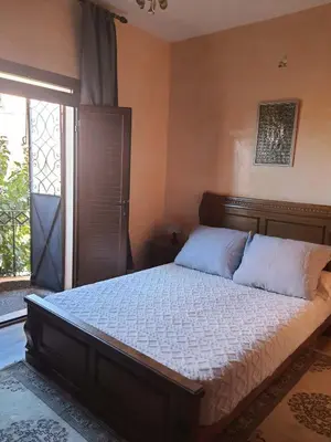 a bedroom with a large bed with white sheets and a window at dar soukaina in Marrakech