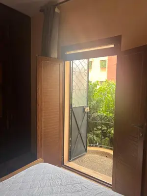 an open glass door with a view of a garden at dar soukaina in Marrakech