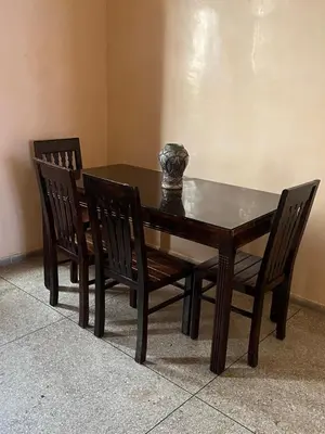 a wooden table with two chairs and a vase on it at dar soukaina in Marrakech