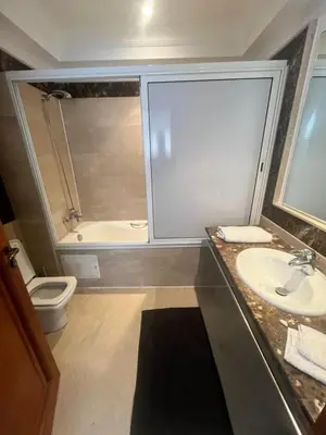 a bathroom with a sink and a toilet and a tub at Prestigieux Appart hivernage in Marrakech