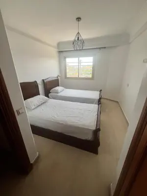 a bedroom with two beds and a window at Prestigieux Appart hivernage in Marrakech