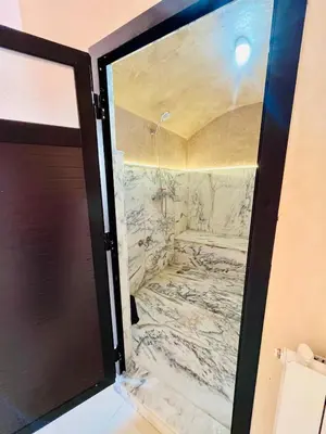 a bathroom with a marble shower with a door at Villa with private pool in Tamensourt