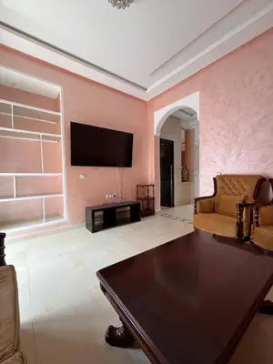 a living room with a flat screen tv on a pink wall at Villa with private pool in Tamensourt