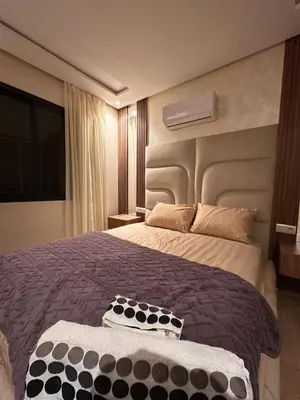 a bedroom with a large bed with a large headboard at appartement luxueux au centre vlle avec piscine in Marrakech