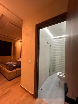 a room with a bathroom with a bed and a shower at appartement luxueux au centre vlle avec piscine in Marrakech
