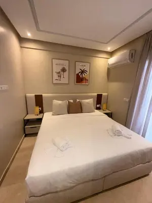 a bedroom with a large bed with white sheets at Appartement de luxe à gueliz neuf et moderne in Marrakech
