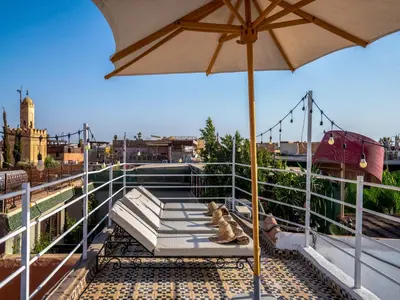 an umbrella sitting on top of a balcony with shoes at Riad Fleur De Sable in Marrakech