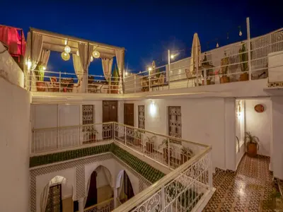 a view of a building with a balcony at night at Riad Fleur De Sable in Marrakech
