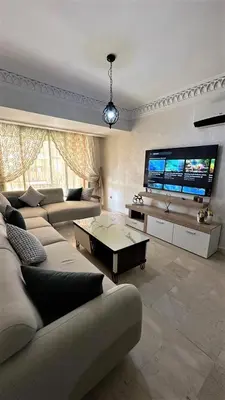 a living room with couches and a large flat screen tv at Luxury & Cozy Apt in Hivernage in Marrakech