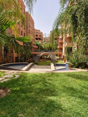 a park with a bridge and some grass and buildings at Luxury & Cozy Apt in Hivernage in Marrakech