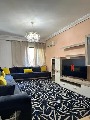 a living room with a blue couch and a tv at Elegant apartment in the heart of Gueliz in Marrakech