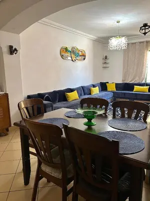 a dining room with a table and chairs and a couch at Elegant apartment in the heart of Gueliz in Marrakech