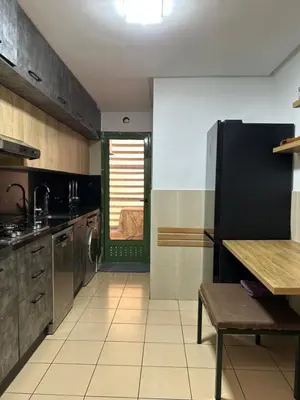 a kitchen with a table and a black refrigerator at Elegant apartment in the heart of Gueliz in Marrakech