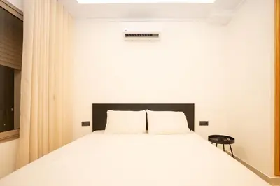 a bedroom with a white bed with a black headboard at Villa Meraki in Marrakech